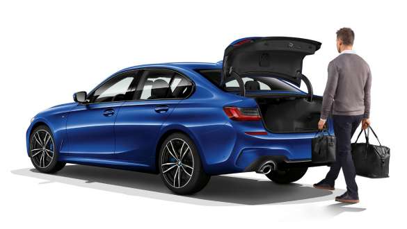 BMW 3. seeria Sedaan (G20), automaatne pagasiluugi avamine. BMW 3. seeria Sedaan (G20), kolm neljandikku tagantvaade, juht jalaga automaatset pagasiluuki avamas.