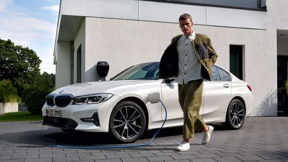 BMW 3. seeria Sedaan 2021 G20 pistikhübriid, kolm neljandikku eestvaade, laadimas BMW 3. seeria Sedaan 2021 G20 pistikhübriid, kolm neljandikku eestvaade, laadimas koos modelliga