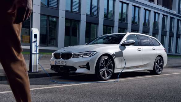 Pistikhübriid BMW 3. seeria Touring 2021 G21, kolm neljandikku eestvaade, laadimas Pistikhübriid BMW 3. seeria Touring 2021 G21, kolm neljandikku eestvaade, maja ees laadimas