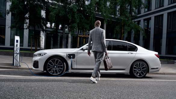 BMW 745e Sedan pistikhübriid G11 G12 Mineral White metallik, külgvaade laadimispunktis BMW 745e Sedan pistikhübriid G11 G12 Mineral White metallik, külgvaade laadimispunkti ees koos modelliga