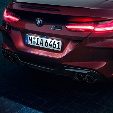 BMW M8 Competition Cabrio, tagaosa lähivaade. BMW M8 Competition Cabrio toonis Motegi Red metallik, lähivaade tagaosast koos LED-tagatulede ja M8 Competitioni embleemiga.