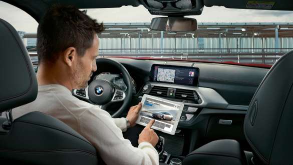 BMW Connected. BMW X4 M sõiduautod, BMW Connected, valgustatud gloobust käes hoidev naine.