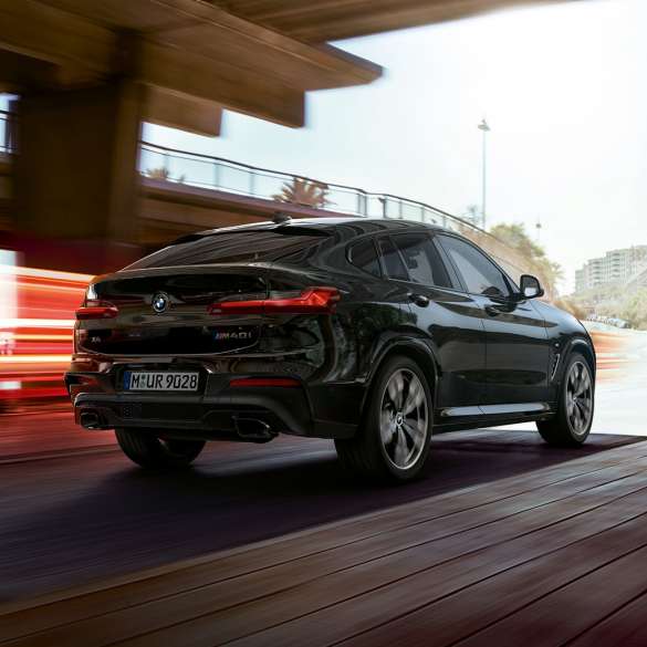 BMW X4 M40i, kolm neljandikku eestvaates. Black Sapphire metallikvärvi BMW X4 M40i, sõitmas, välisilme, kolm neljandikku eestvaade valgusribaga.