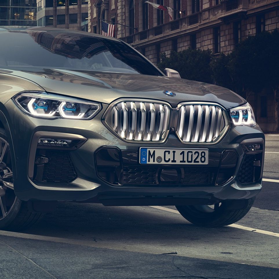 BMW X6 M50i paigal seismas BMW X6 M50i kolm neljandikku eestvaates, seismas linnakeskkonnas