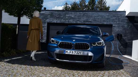 Pistikhübriid BMW X2 xDrive25e F39, eestvaade garaaži ees Pistikhübriid BMW X2 xDrive25e F39, eestvaade garaaži ees koos modelliga