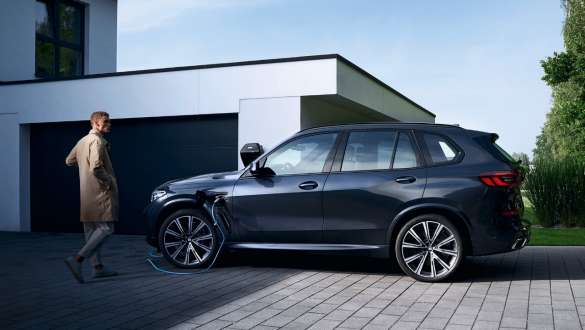BMW X5 xDrive45e G05 pistikhübriid, külgvaade garaaži ees BMW X5 xDrive45e G05 pistikhübriid, külgvaade garaaži ees koos modelliga