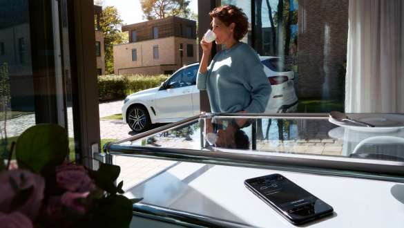 Tarkvara kauguuendus, BMW X5 Naine kohvi joomas, uuendades samal ajal oma BMW X5 tarkvara kauguuenduse abil, G05 2018
