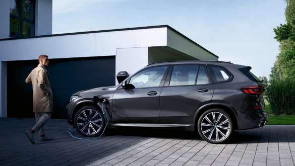BMW X5 xDrive45e G05 pistikhübriid, külgvaade garaaži ees BMW X5 xDrive45e G05 pistikhübriid, külgvaade garaaži ees koos modelliga