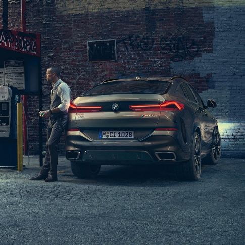 BMW X6 tagaosa. BMW X6 in rear perspective in front of an urban setting.