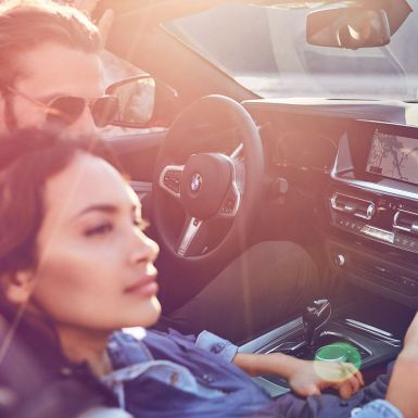 BMW Z4 Roadster koos naise ja mehega Tumedapäine naine ja mees BMW Z4 Roadsteris