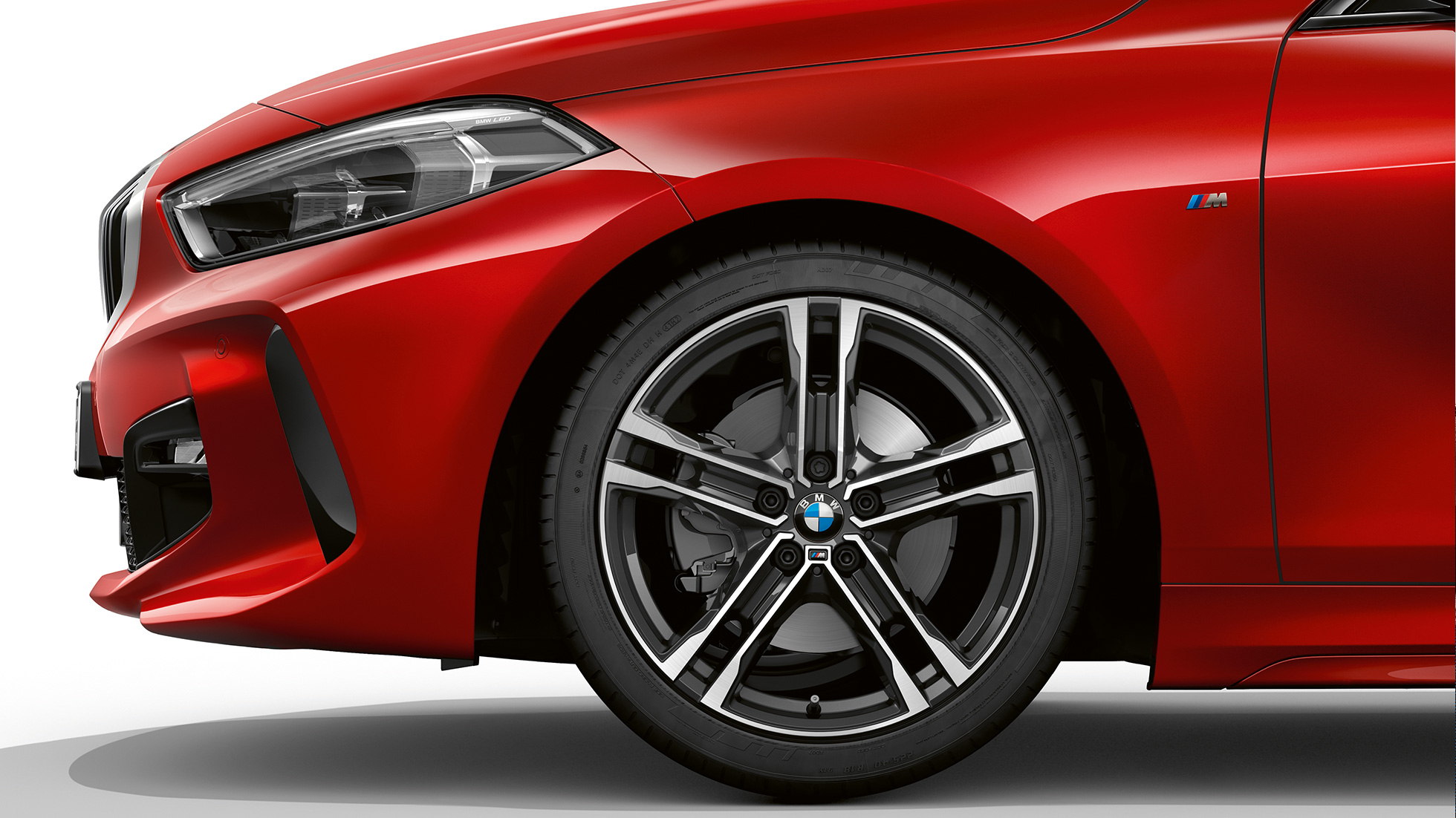 BMW 1. seeria mudel M Sport, külgmine eestvaade. BMW 1. seeria mudel M Sport värvitoonis Melbourne Red metallik, eestvaade küljelt koos 17-tolliste kergmetallvelgedega Double-spoke 550 M style, Bicolour.