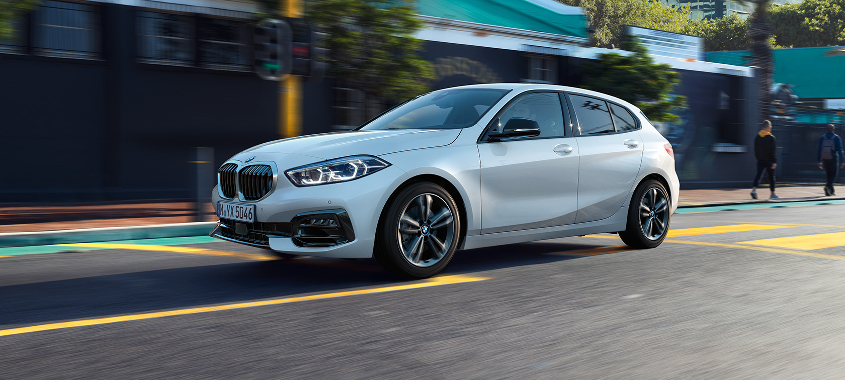 BMW 1. seeria mudeli Sport Line kolm neljandikku külgvaade. BMW 1. seeria mudel Sport Line värvitoonis Mineral White metallik, kolm neljandikku külgvaade sõidu ajal.