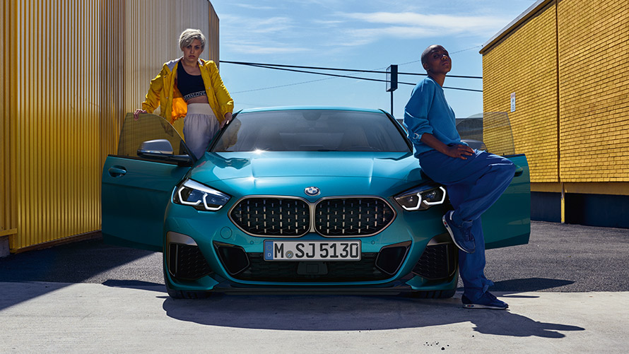 BMW 2. seeria Gran Coupé F44, eestvaade BMW 2. seeria Gran Coupé F44, Snapper Rocks Blue, eestvaade avatud ustega ja kahe inimesega sõiduki juures