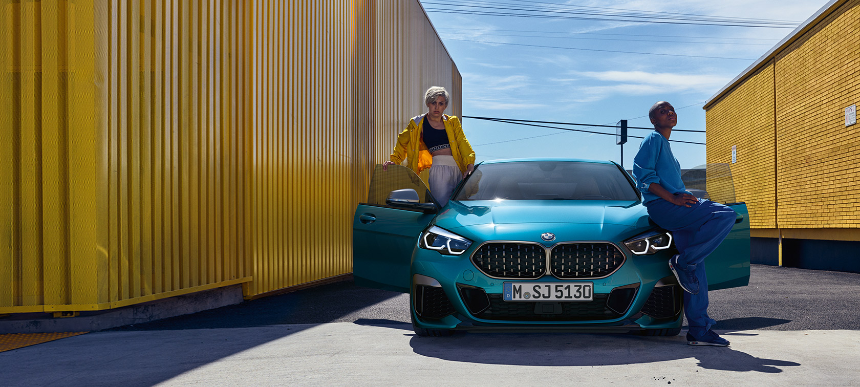 BMW 2. seeria Gran Coupé F44, eestvaade BMW 2. seeria Gran Coupé F44, Snapper Rocks Blue, eestvaade avatud ustega ja kahe inimesega sõiduki juures