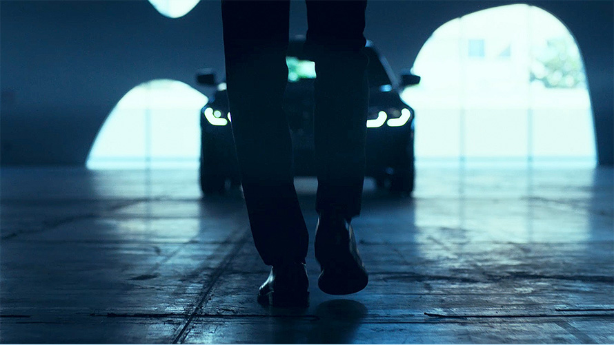 BMW 3. seeria Sedaan (G20), eestvaade. BMW 3. seeria Sedaan (G20) asfaldil, vaade auto ees kõndiva mehe tagant.