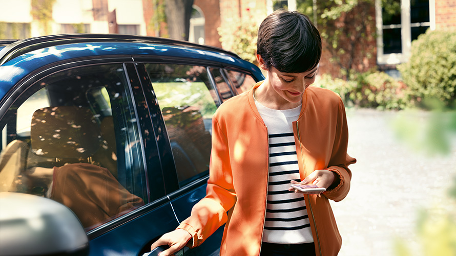 BMW Service, naine nutitelefoniga BMW ukse juures BMW Service, naine nutitelefoniga BMW ukse juures