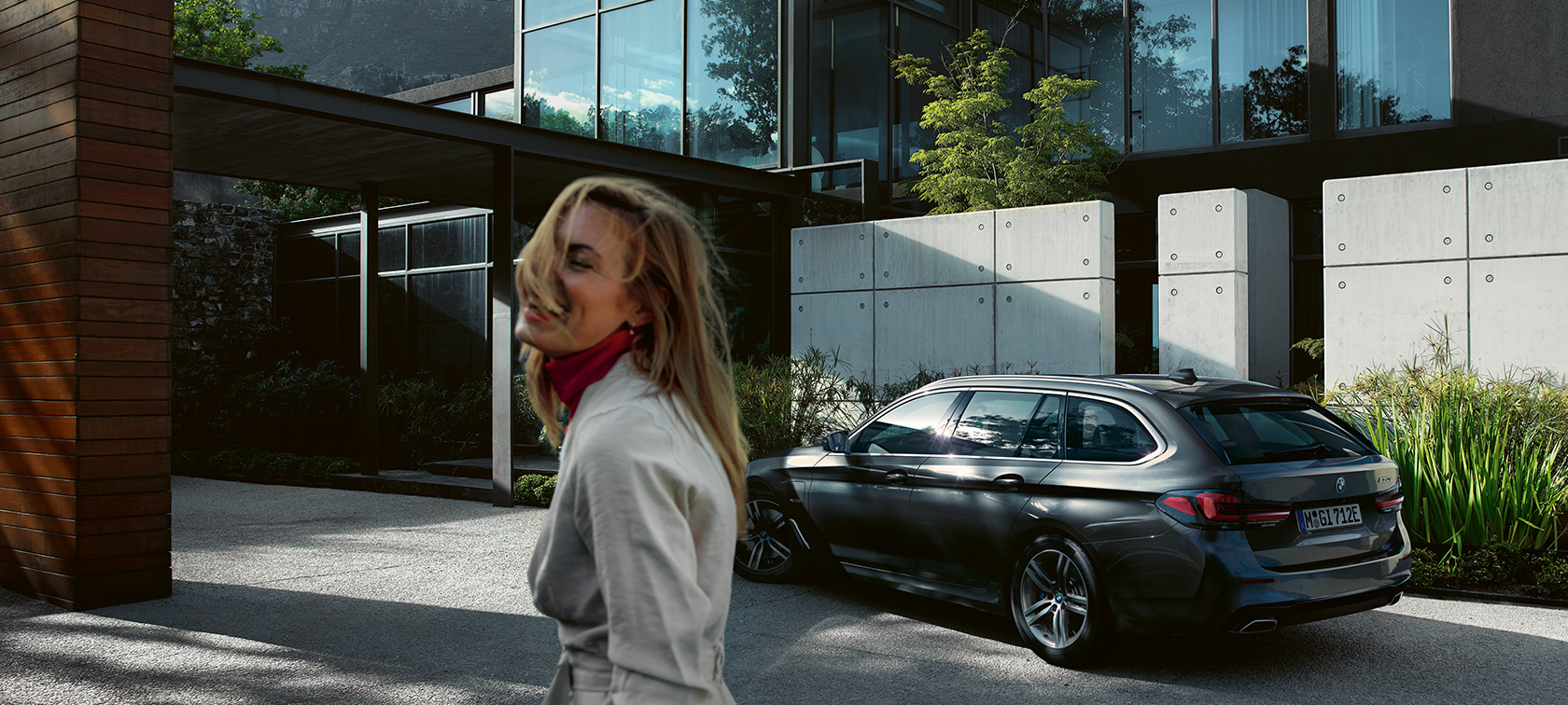 BMW 5. seeria Touring G31, naine seisab parkiva BMW ees BMW 5. seeria Touring G31 Facelift 2020, naine seisab parkiva BMW ees