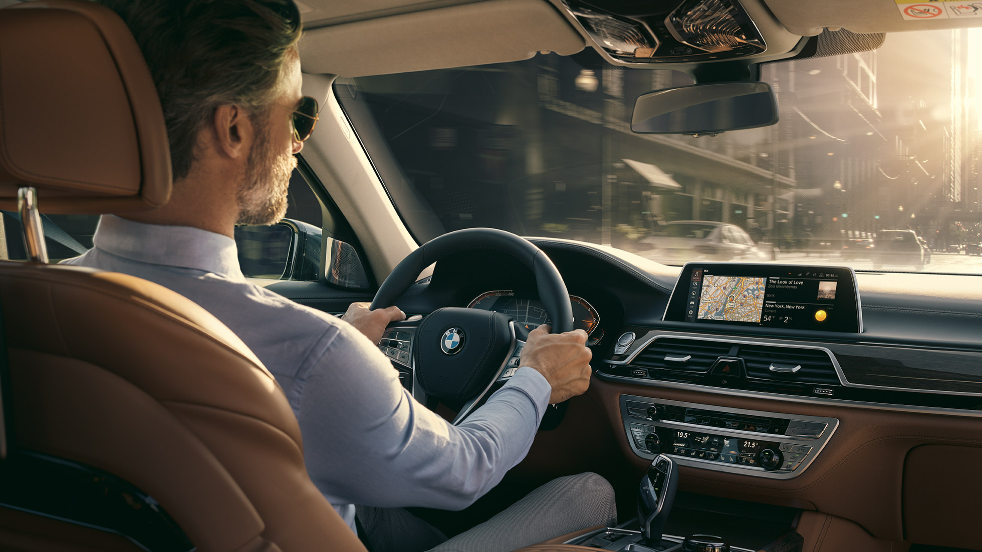 BMW 7. seeria Sedani ühenduvus BMW 7. seeria Sedaan: mees istub BMW-s ja kasutab ühenduvusfunktsioone