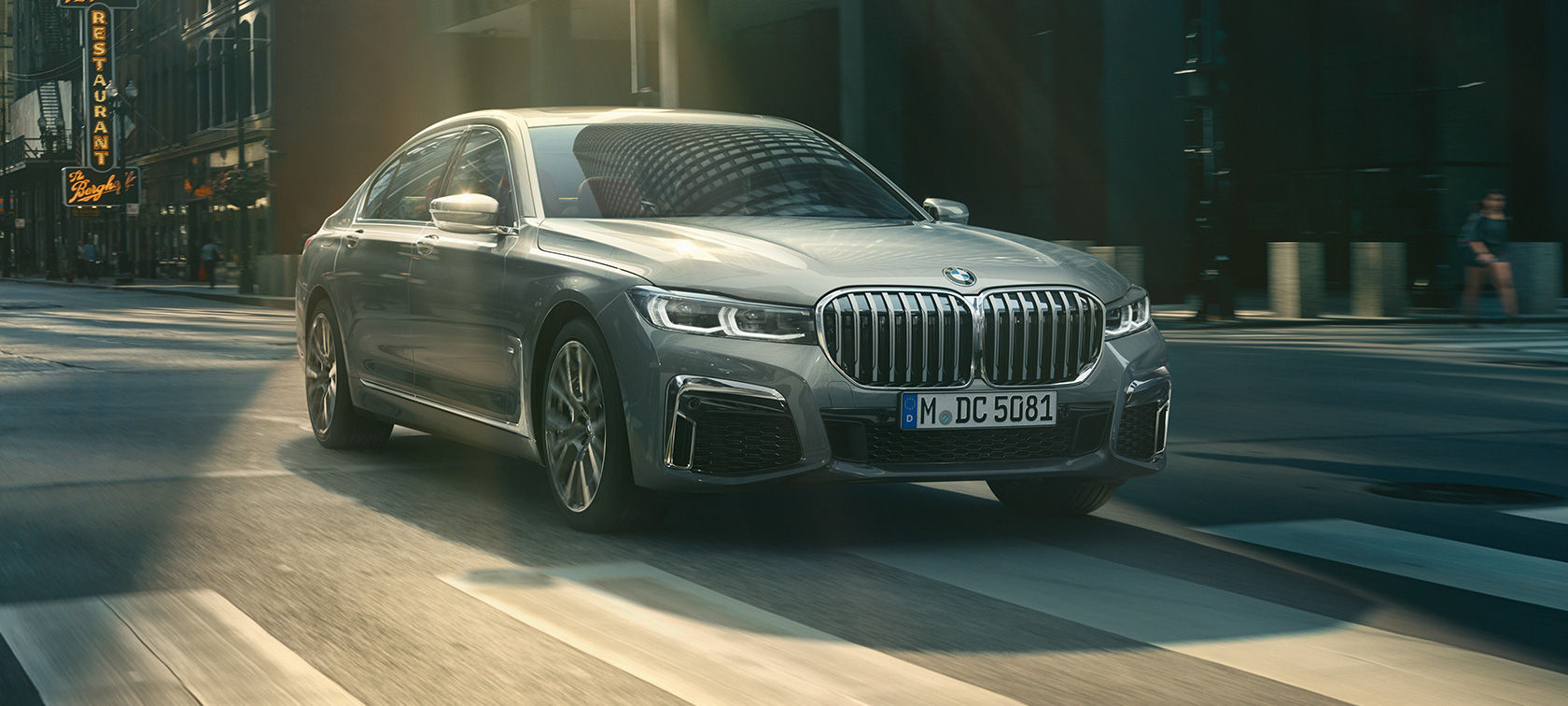 BMW 7. seeria Sedan G11 G12 2019 Bernina Grey Amber Effect, kolm neljandikku eestvaade sõites läbi linnakeskkonna BMW 7. seeria Sedan G11 G12 2019 Bernina Grey Amber Effect, kolm neljandikku eestvaade sõites