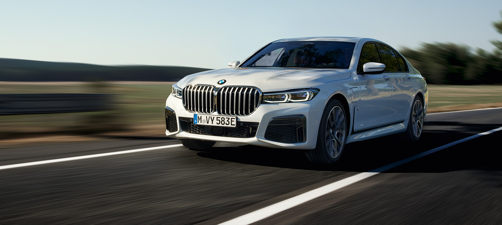 BMW 745e Sedan pistikhübriid G11 G12 Mineral White kolm neljandikku eestvaade BMW 745e Sedan pistikhübriid G11 G12 Mineral White metallik kolm neljandikku eestvaade sõites maateel