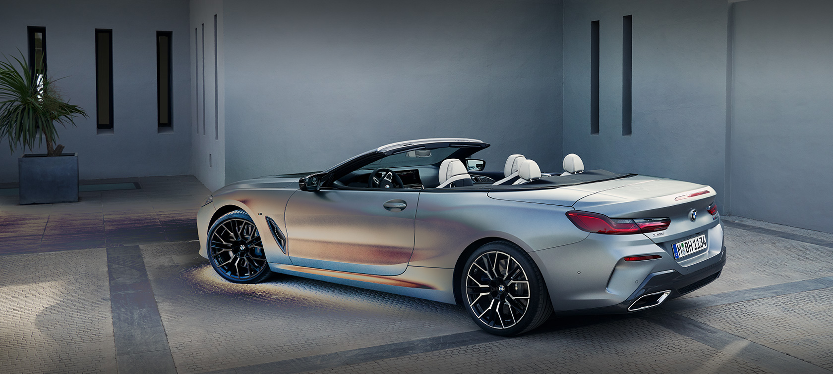 BMW 8. seeria Cabrio G14 LCI Facelift 2022 BMW Individual Frozen Pure Grey metallik seismas hoone ees koos meesmodelliga, mees toetub vastu autot, külgvaade