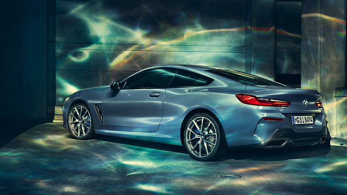 BMW 8. seeria Coupé, kolm neljandikku tagantvaade. BMW 8. seeria Coupé kolm neljandikku tagantvaate pilt öise linna taustal.