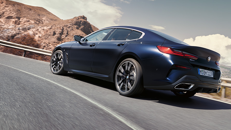 BMW 840i xDrive Gran Coupé G16 LCI Facelift 2022 sõitmas mägiteel BMW 840i xDrive Gran Coupé G16 LCI Facelift 2022 Portimao Blue metallik kolm neljandikku eest-tagantvaade sõitmas mägiteel