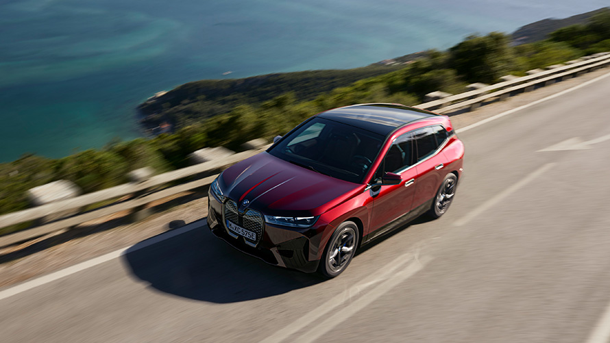 BMW iX i20 elektrilise SUV BMW iX xDrive50 sooritusvõime BMW iX i20 2021 elektriline SUV BMW iX xDrive50 Aventurin Red sõitmas tänaval, sooritusvõime