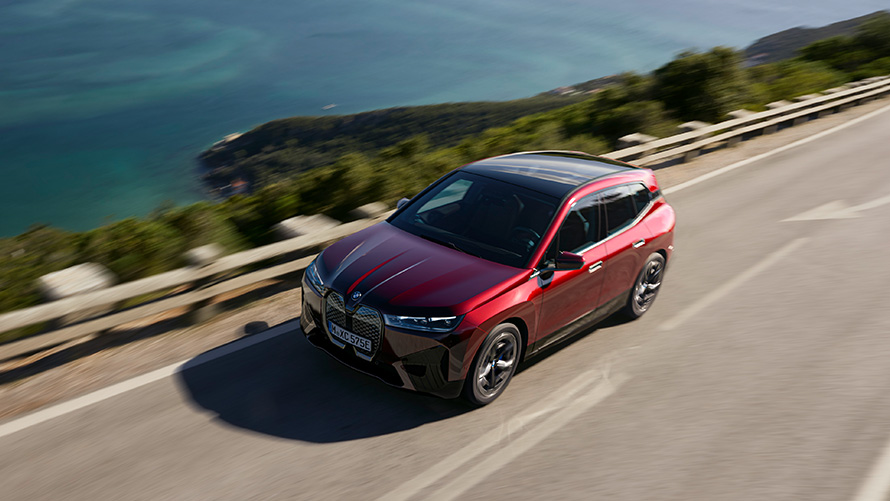BMW iX i20, elektriline SUV BMW iX xDrive50, sooritusvõime BMW iX i20 2021, elektriline SUV BMW iX xDrive50 Aventurin Red, sõitmas tänaval, sooritusvõime