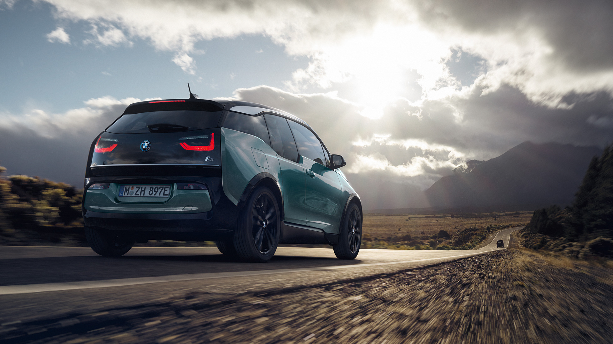 BMW i3 2018, kolm neljandikku tagantvaade sõites kiirteel BMW i3 I01 2018 Jucaro Beige metallikvärv koos Frozen Grey metallikviimistlusega, kolm neljandikku tagantvaade, sõites kiirteel