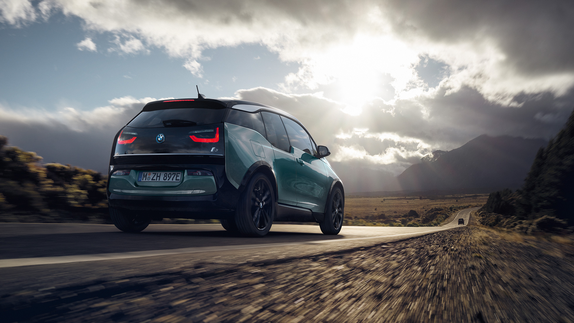 BMW i3 2018, kolm neljandikku tagantvaade sõites kiirteel BMW i3 I01 2018 Jucaro Beige metallikvärv koos Frozen Grey metallikviimistlusega, kolm neljandikku tagantvaade, sõites kiirteel