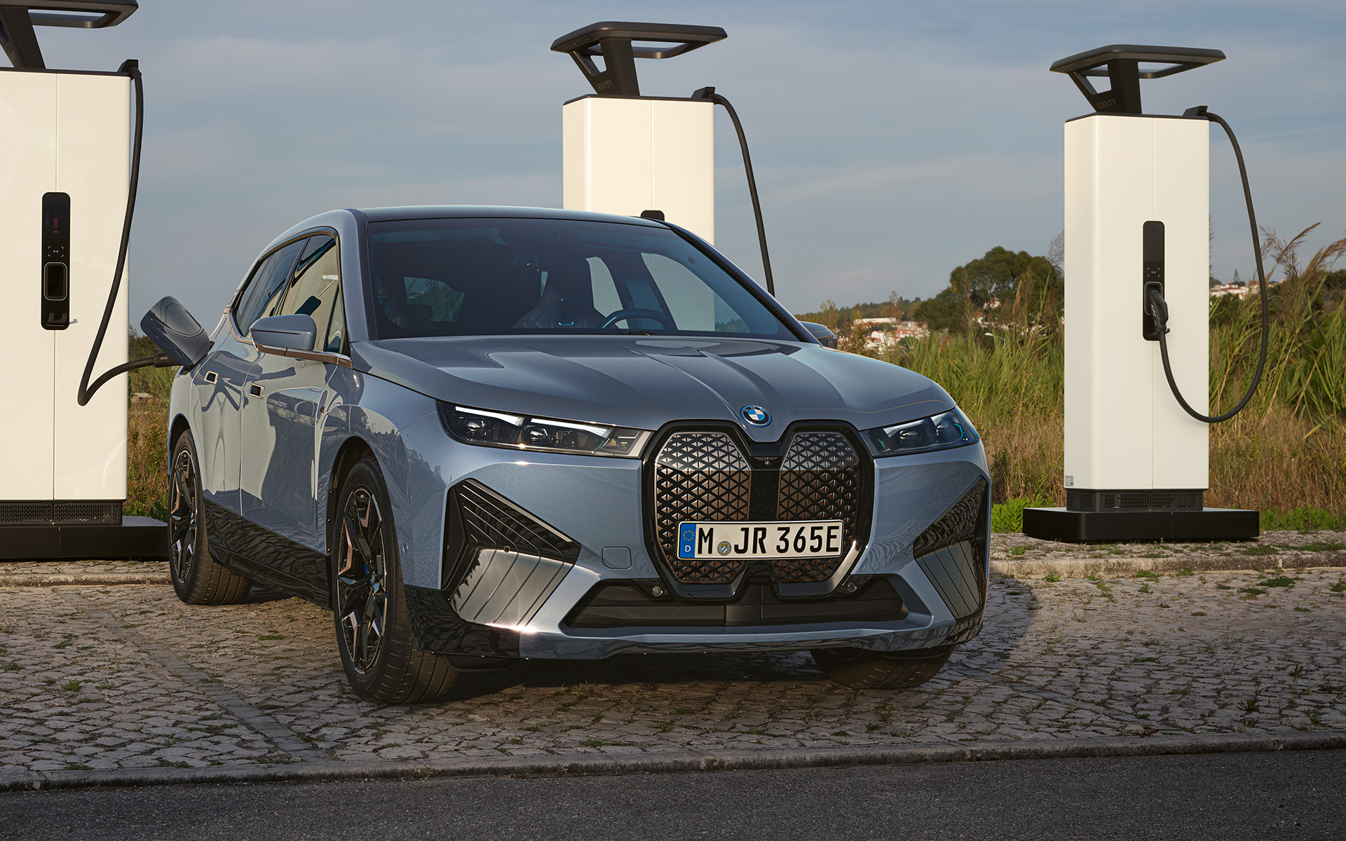 BMW iX M60 i20 2022 elektrimaastur, BMW Individual Storm Bay metallik, eestvaates suure võimsusega laadimisjaamas