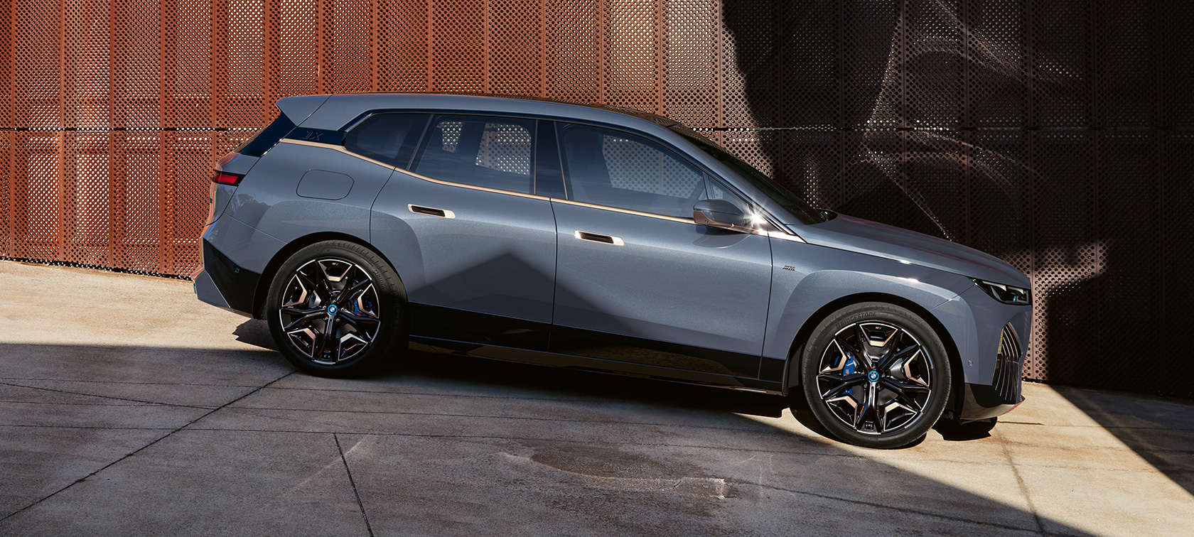 BMW iX M60 i20 2022 elektrimaastur, BMW Individual Storm Bay metallik, külgvaade parkimas