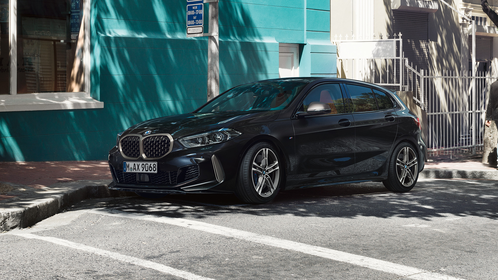 BMW M135i xDrive, kolm neljandikku külgvaade. Uus BMW M135i xDrive toonis Black Sapphire metallik, kolm neljandikku külgvaates parkimas.
