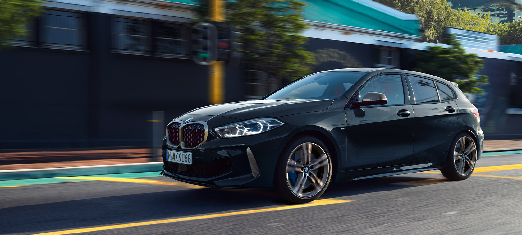 BMW 1. seeria M135i xDrive (F40) värvitoonis Black Sapphire metallik, sõitev auto linnakeskkonnas