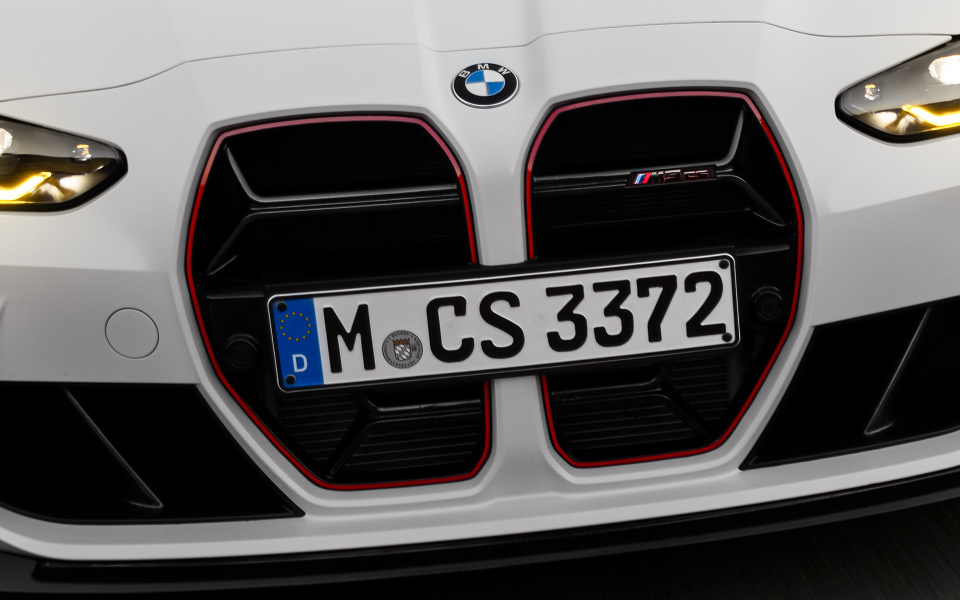 CS-spetsiifiline must neerukujuline iluvõre koos punase erimudeli signatuuriga, BMW M3 CS G80 BMW M3 CS G80, CS-spetsiifiline must neerukujuline iluvõre koos punase erimudeli signatuuriga, eestvaade sõites