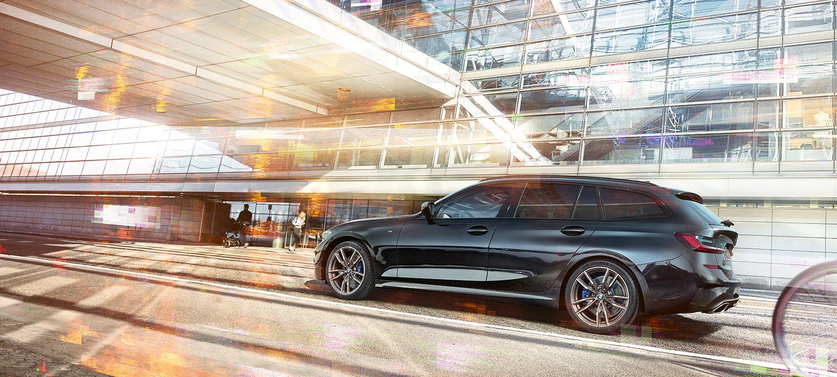 BMW M340i xDrive Touring, külgvaade sõites BMW M340i xDrive Touring, külgvaade klaashoone ees