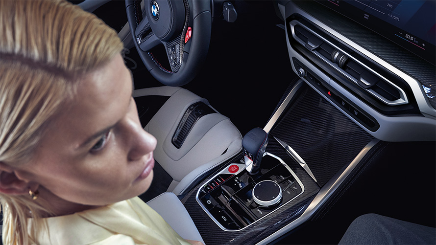 M xDrive’iga BMW M4 Competition Cabrio G83 2021, salong, keskkonsool M xDrive’iga BMW M4 Competition Cabrio G83 2021, keskkonsool ja naine kõrvalistujaistmel