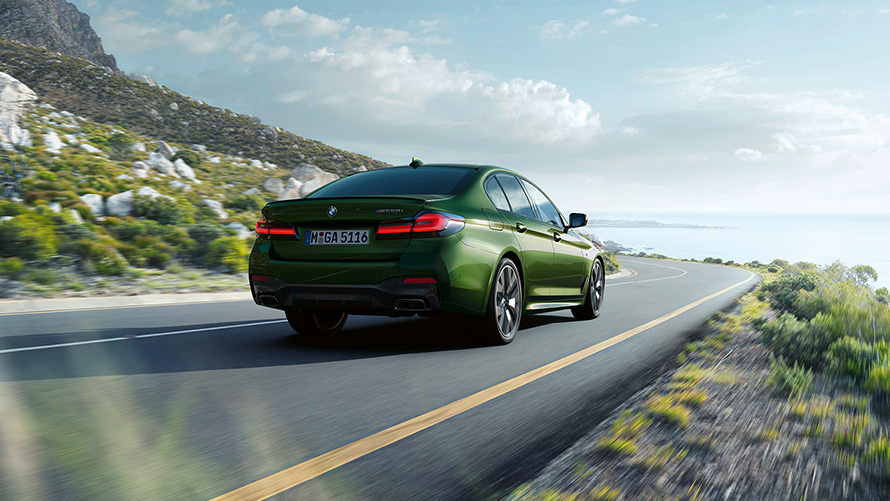BMW M550i xDrive Sedaan G30 LCI Facelift 2020, BMW Individual Verde Ermes metallik, kolm neljandikku tagantvaade, sõitmas