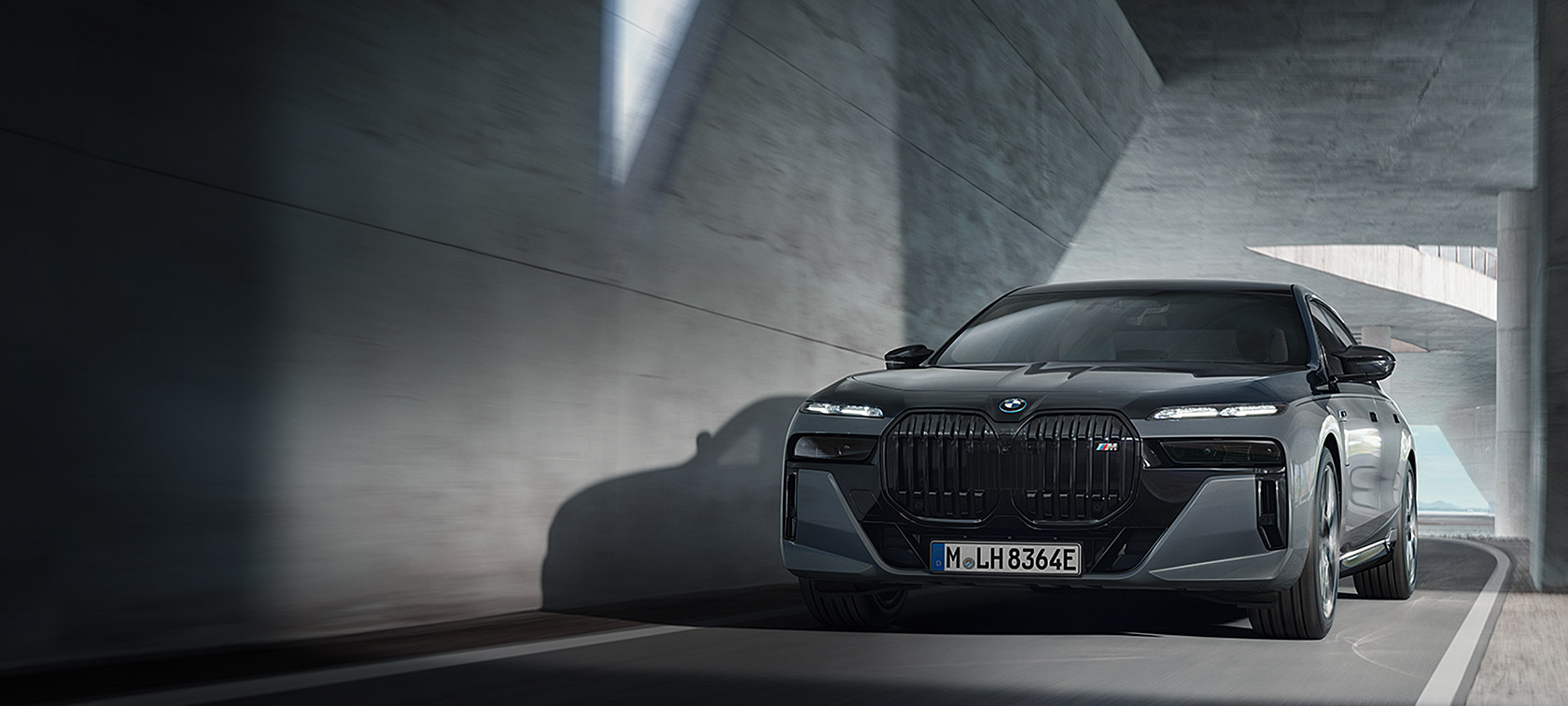 BMW M760e xDrive Sedaan G70 M Performance’i pakett, BMW Individuali kahetooniline Black Sapphire metallik kerevärv, BMW Individuali Dravite Grey metallik, eestvaade tänaval sõites