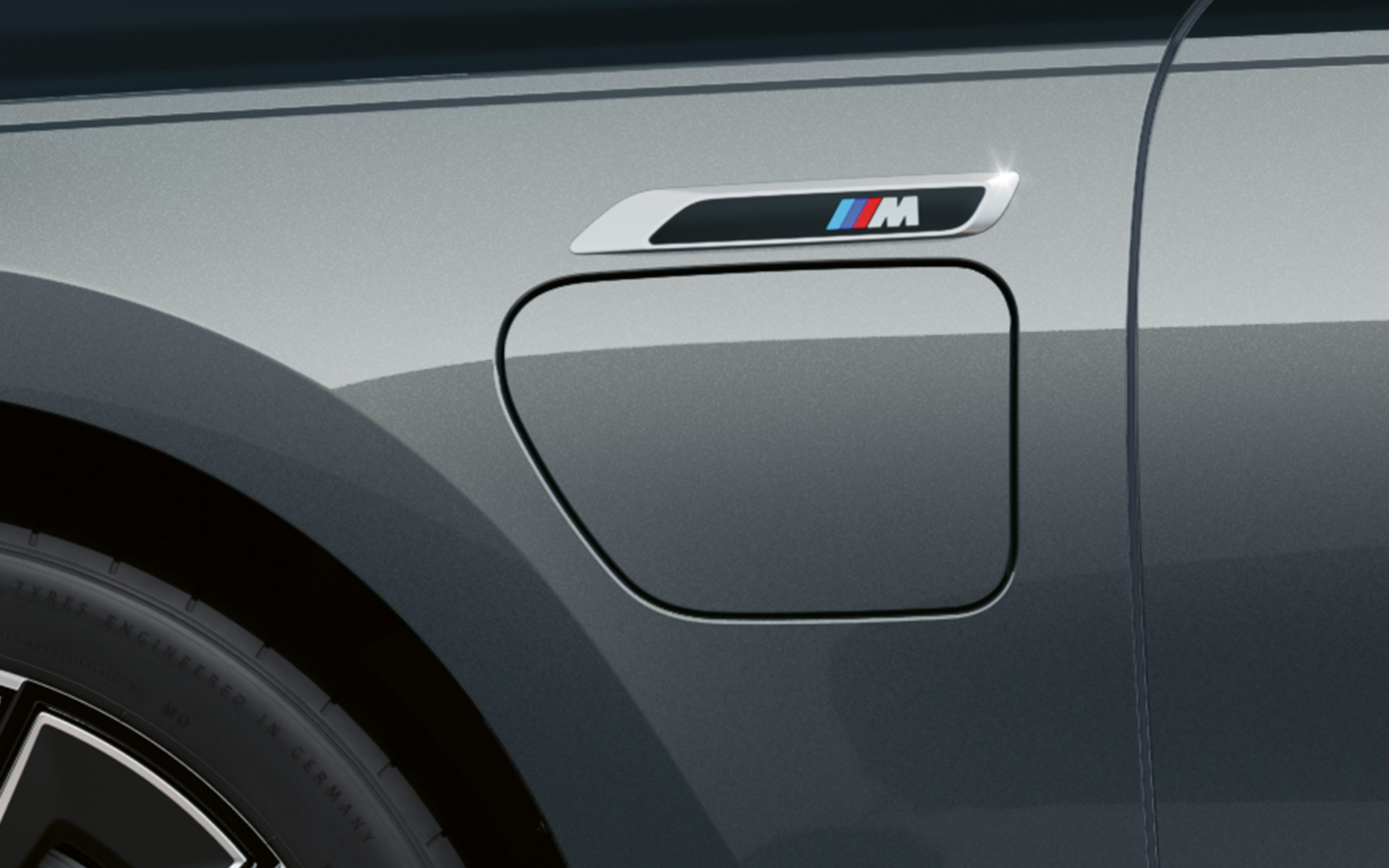 M-embleem, BMW M760e xDrive Sedaan G70, M Performance’i pakett, BMW Individuali kahetooniline värviviimistlus Black Sapphire metallik, BMW Individual Dravite Grey metallik, lähivõte, külgvaade