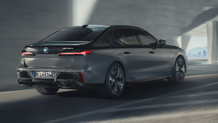 BMW M760e xDrive Sedaan G70, M Performance’i pakett BMW M760e xDrive Sedaan G70, M Performance’i pakett, BMW Individuali kahetooniline värviviimistlus Black Sapphire metallik, BMW Individual Dravite Grey metallik, kolm neljandikku tagantvaade tänaval sõites