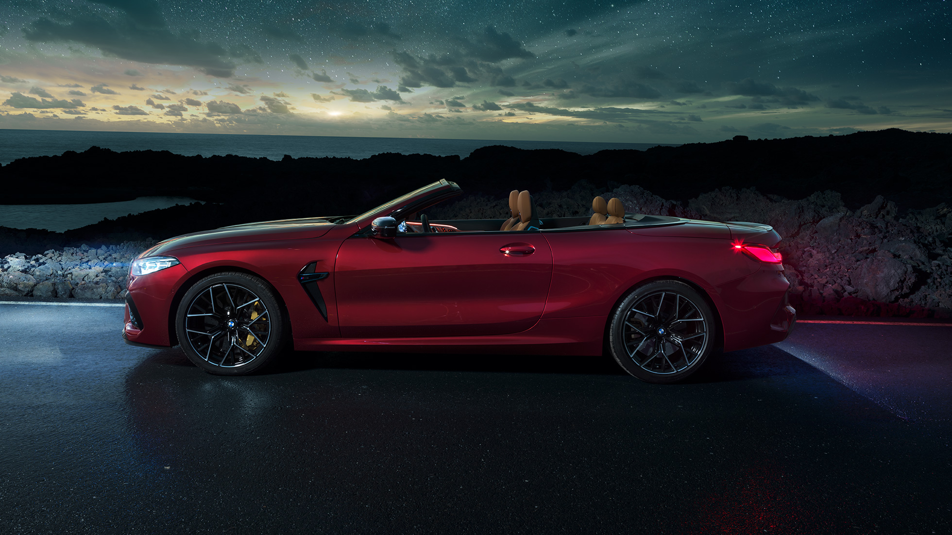 BMW M8 Competition Cabrio, külgvaade. BMW M8 Competition Cabrio toonis Motegi Red metallik, avatud pehme katusega, külgvaade, seismas tähistaeva all.