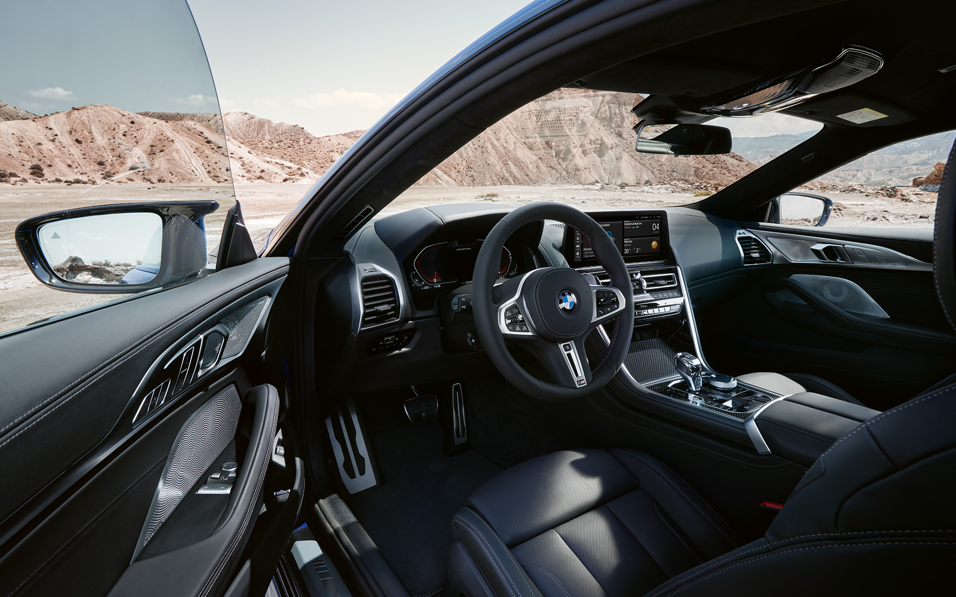 BMW M850i xDrive Coupé G15 LCI Facelift 2022 juhile orienteeritud juhikoht koos nahkkattega M-rooli ja avatud esiuksega