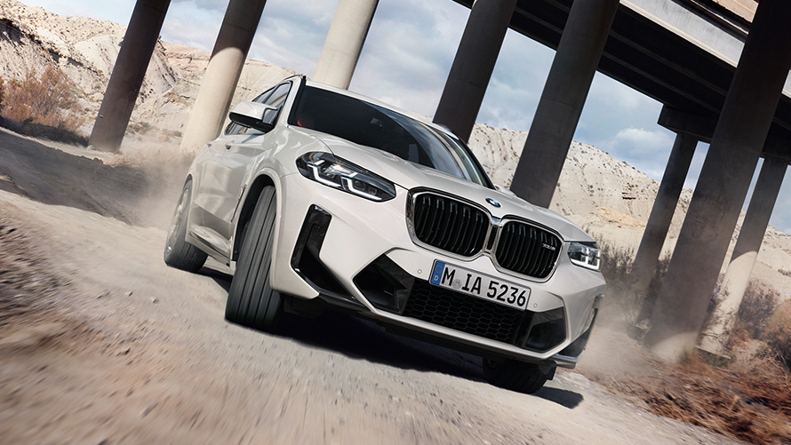 BMW X3 M F97 LCI Facelift 2021, toonis Alpine White, kolm neljandikku eestvaade, kurvis sõitmas
