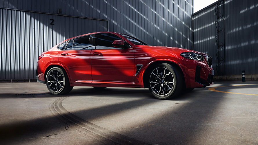 BMW X4 M F98 LCI Facelift 2021, toonis Toronto Red metallik, külgvaade tehasehoone ees
