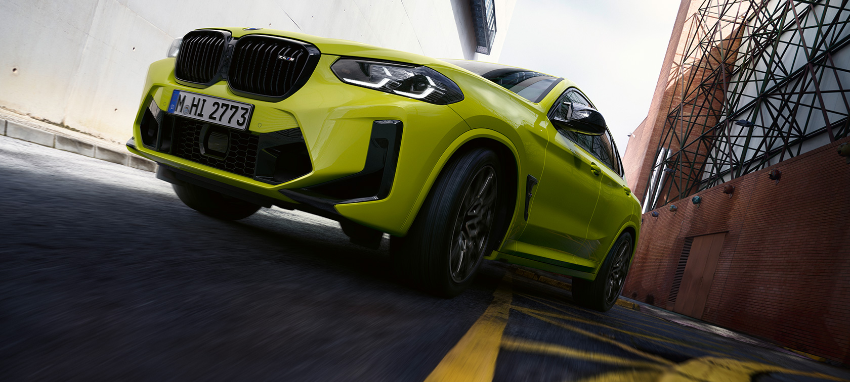 Kolm neljandikku eestvaade altpoolt, BMW X4 M Competition F98 LCI 2021 BMW X4 M Competition F98 LCI Facelift 2021, toonis Sao Paulo Yellow, kolm neljandikku eestvaade altpoolt, sõitmas kanjonis majade vahel