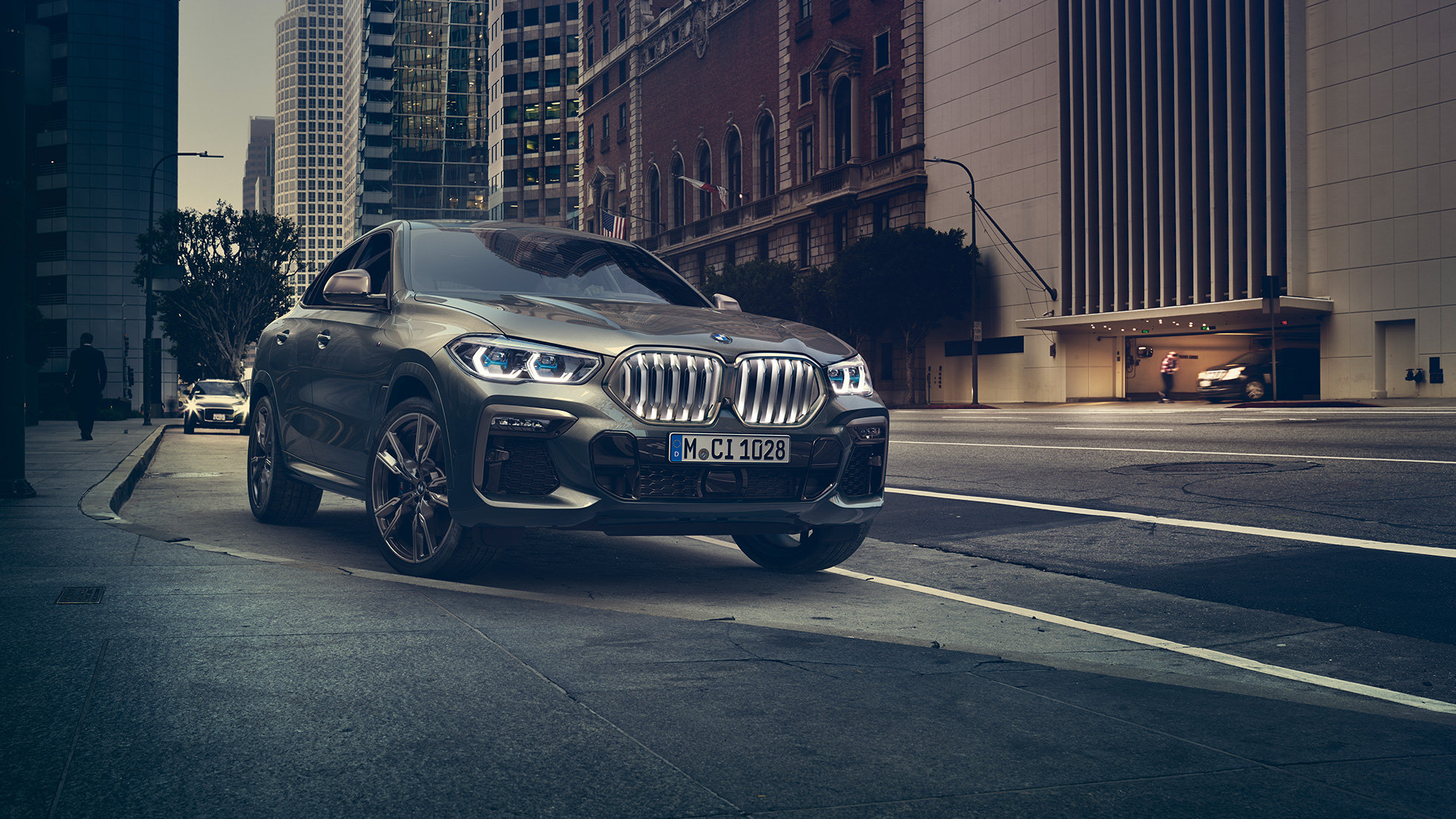 BMW X6 M50i paigal seismas BMW X6 M50i kolm neljandikku eestvaates, seismas linnakeskkonnas