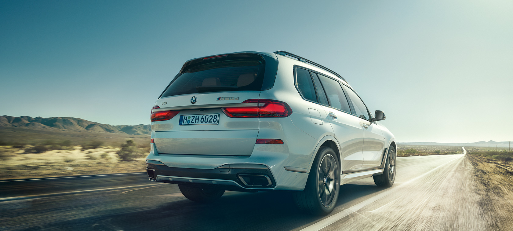 BMW X7 M50d, tagantvaade BMW X7 M50d Mineral White toonis, tühjal kiirteel sõitmine, tagantvaade, G07, 2019