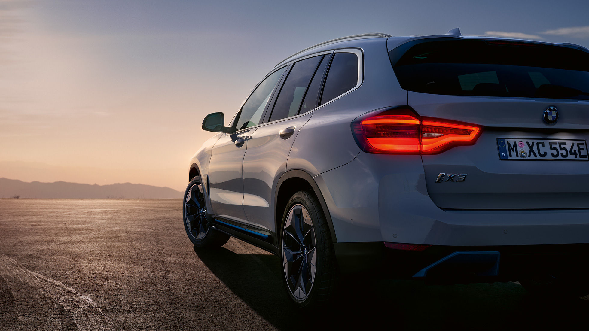 BMW iX3 G08 kolm neljandikku tagantvaade maanteel sõites BMW iX3 G08 2020 Mineral White metallik, kolm neljandikku tagantvaade maanteel sõites